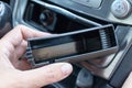 A hand of a driver holding a clean washed empty plastic car ashtray, stop, quit smoking in car Royalty Free Stock Photo