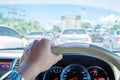 Hand of driver holding steering wheel, with traffic view in the city Royalty Free Stock Photo