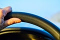 The hand of driver on the steering wheel of the car and the blue sky in the evening outside the windshield Royalty Free Stock Photo