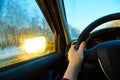 The hand of driver on the steering wheel of the car and the blue sky in the evening outside the windshield Royalty Free Stock Photo