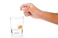 Hand dropping effervescent vitamin C tablet into glass of water