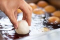 Hand dropping flour into oil for frying. preparing christmas fritters.