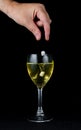 A hand dropping pills into a glass of wine Royalty Free Stock Photo