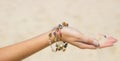 Hand dropping sand between the fingers with crystal bracelet