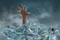 Hand drown in large garbage pile with dark cloud sky
