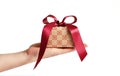 Hand with ecru gift box with dark red satin ribbon Royalty Free Stock Photo