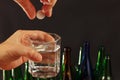 Hand with an effervescent tablet from hangover over a glass of water on dark background. Royalty Free Stock Photo