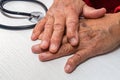 Hand of elderly man with osteoarthritis at doctor`s office on white table Royalty Free Stock Photo