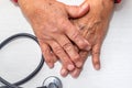 Hand of elderly man with osteoarthritis at doctor`s office on white table Royalty Free Stock Photo