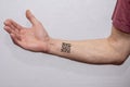 The hand of an elderly man with a tattooed QR code on a light background. Concept: assigning QR codes to people with antibodies to