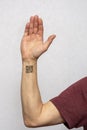 The hand of an elderly man with a tattooed QR code on a light background. Concept: assigning QR codes to people with antibodies to