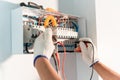 Hand of Electrician engineer work tester measuring voltage and current of power electric line in electrical cabinet control. Royalty Free Stock Photo