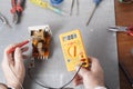 Hand of electrician with multimeter probe at electrical switchgear cabinet. Engineering tools Royalty Free Stock Photo