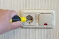 Hand Of An Electrician To Repair A Wall Socket. Closeup of man electrician's hand repairing an electrical outlet. Hazardous Royalty Free Stock Photo