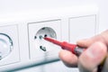 Hand Of An Electrician Using A Phase Tester Screwdriver To Repair A Wall Socket Royalty Free Stock Photo