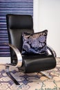 Hand embroidered violet and black pillow on the black chair