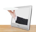 Hand with empty white plate leans out TV screen Royalty Free Stock Photo