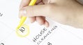 Hand encircles a date on a calendar with text House Cleaning yellow felt-tip pen Royalty Free Stock Photo