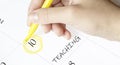 Hand encircles a date on a calendar with text TEACHING yellow felt-tip pen