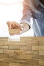 Hand of engineer playing a blocks wood tower game & x28;jenga& x29; on blu Royalty Free Stock Photo