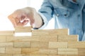 Hand of engineer playing a blocks wood tower game & x28;jenga& x29; on blu Royalty Free Stock Photo