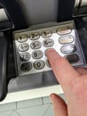 Hand enters a PIN Number into a bancomat Royalty Free Stock Photo