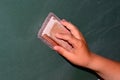 Hand erasing blackboard at school