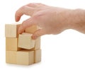 The hand establishes a wooden cube