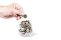 Hand with euro coin and glass jar with money