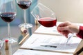 Hand evaluating red wine density at table Royalty Free Stock Photo