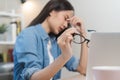 Hand of exhausted, stressed asian young business woman working, took off glasses, massage nose from dry eyes, suffer on hard work Royalty Free Stock Photo