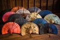 hand fans arranged in a circle on a rustic wooden table