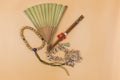 Hand fans, chopsticks, Buddhist prayer beads, shells on a beige background Royalty Free Stock Photo