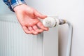 Hand on the faucet or temperature regulator on the radiator of the heating system, selective focus. Background Royalty Free Stock Photo