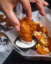 Hand of a female dipping hot wings in a condiment sauce Royalty Free Stock Photo