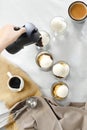Hand of female pouring coffee from moka pot on vanilla ice creams to make affogato coffee put on white tablecloth. Royalty Free Stock Photo