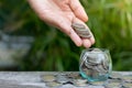 Hand of female putting coins in jar Royalty Free Stock Photo