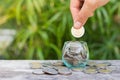 Hand of female putting coins in jar Royalty Free Stock Photo