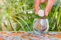 Hand of female putting coins in jar with money stack step growing growth saving money. Royalty Free Stock Photo