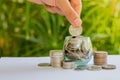 Hand of female putting coins in jar Royalty Free Stock Photo