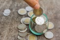 Hand of female putting coins in jar Royalty Free Stock Photo