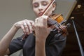 Hand of a female violinist on the fingerboard of a violin takes a chord during music performance