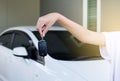 Hand female driver holding car keys with car on background Royalty Free Stock Photo