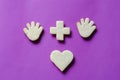 Hand figurines, heart symbol and arithmetic plus sign on a purple background