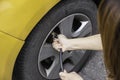 Hand filling air into a car tire, close up Royalty Free Stock Photo