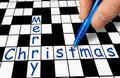 Hand filling in crossword - Merry Christmas Royalty Free Stock Photo