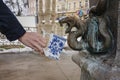 Hand filling a cup with therapeutic mineral water at a natural hot spring in Karlovy Vary