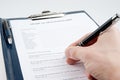 Hand filling in empty medical questionnaire Royalty Free Stock Photo