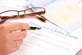 Hand filling in insurance claim form Royalty Free Stock Photo