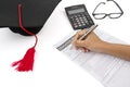 Hand fills education insurance policy on table Royalty Free Stock Photo